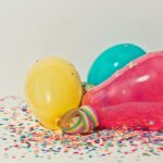Vibrant colorful balloons surrounded by confetti, perfect for party celebrations.